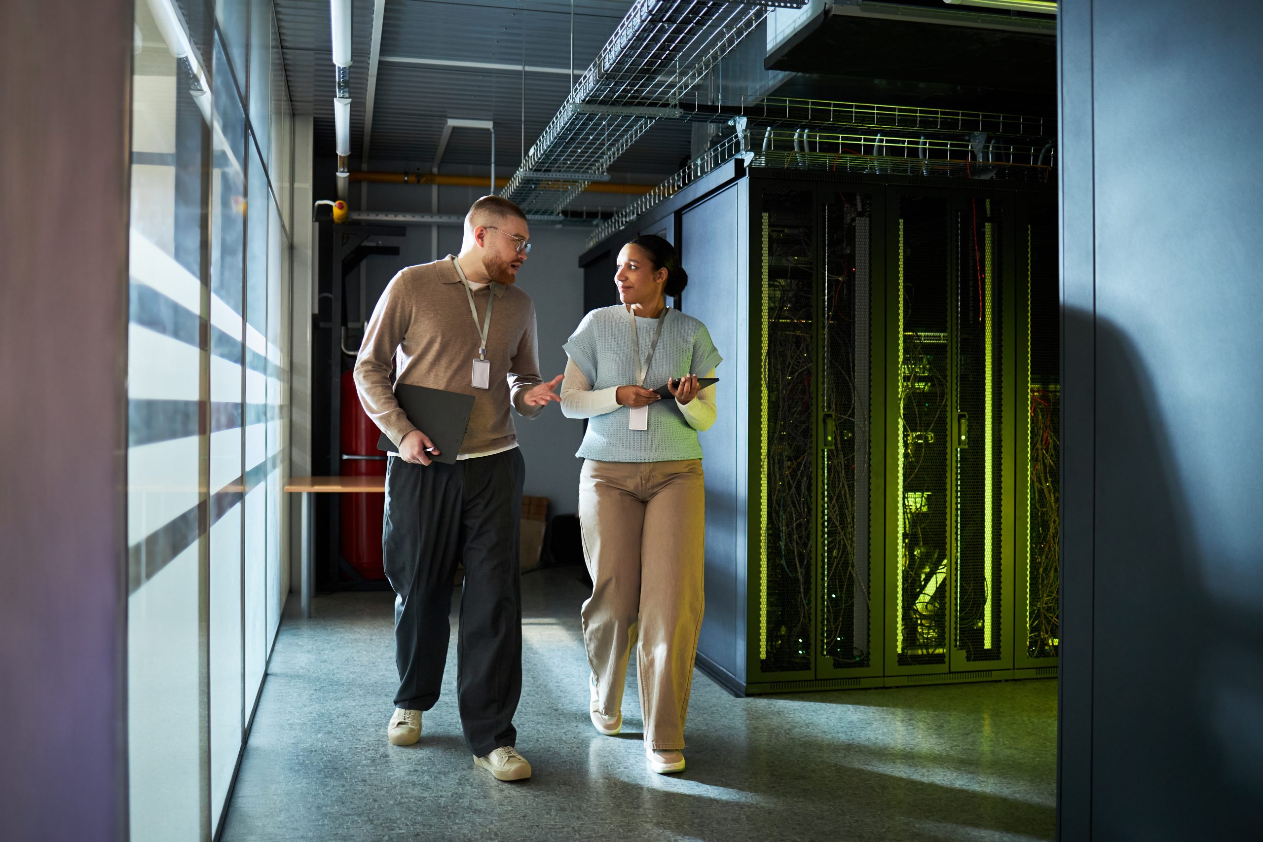 Colleagues Discussing Work while Walking in Server Room